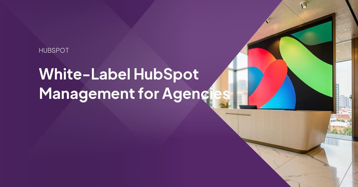Agency team reviewing a white-labeled HubSpot portal dashboard and client reports on a laptop during a delivery handoff.